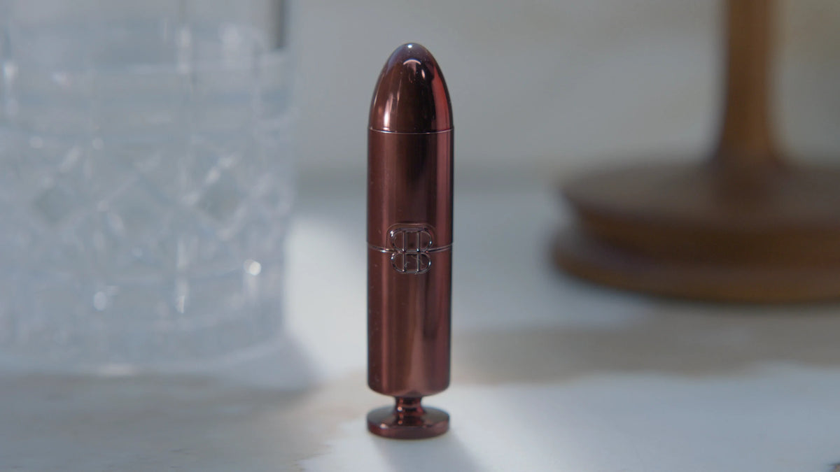 Plan du film : un rouge Eternal Matte posé près d’un verre en cristal